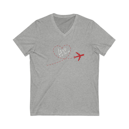 Gray tee with red plain that has a trail that forms the shape of a heart. Within the heart is the text 'Love is in the air'. 