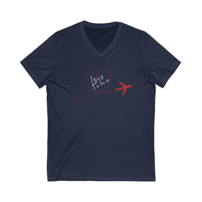 Navy  tee with red plain that has a trail that forms the shape of a heart. Within the heart is the text 'Love is in the air'. 