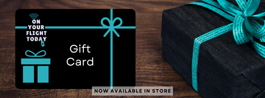 On Your Flight Today gift with black background and green bow and green gift images with text 'Gift Card' in the center. To the right of the gift card is a black gift box wrapped in green ribbon. 